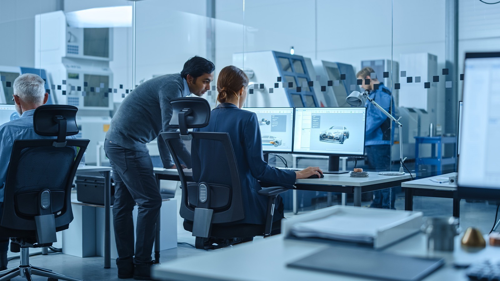 Automotive engineers working on 3D CAD model on computer screen